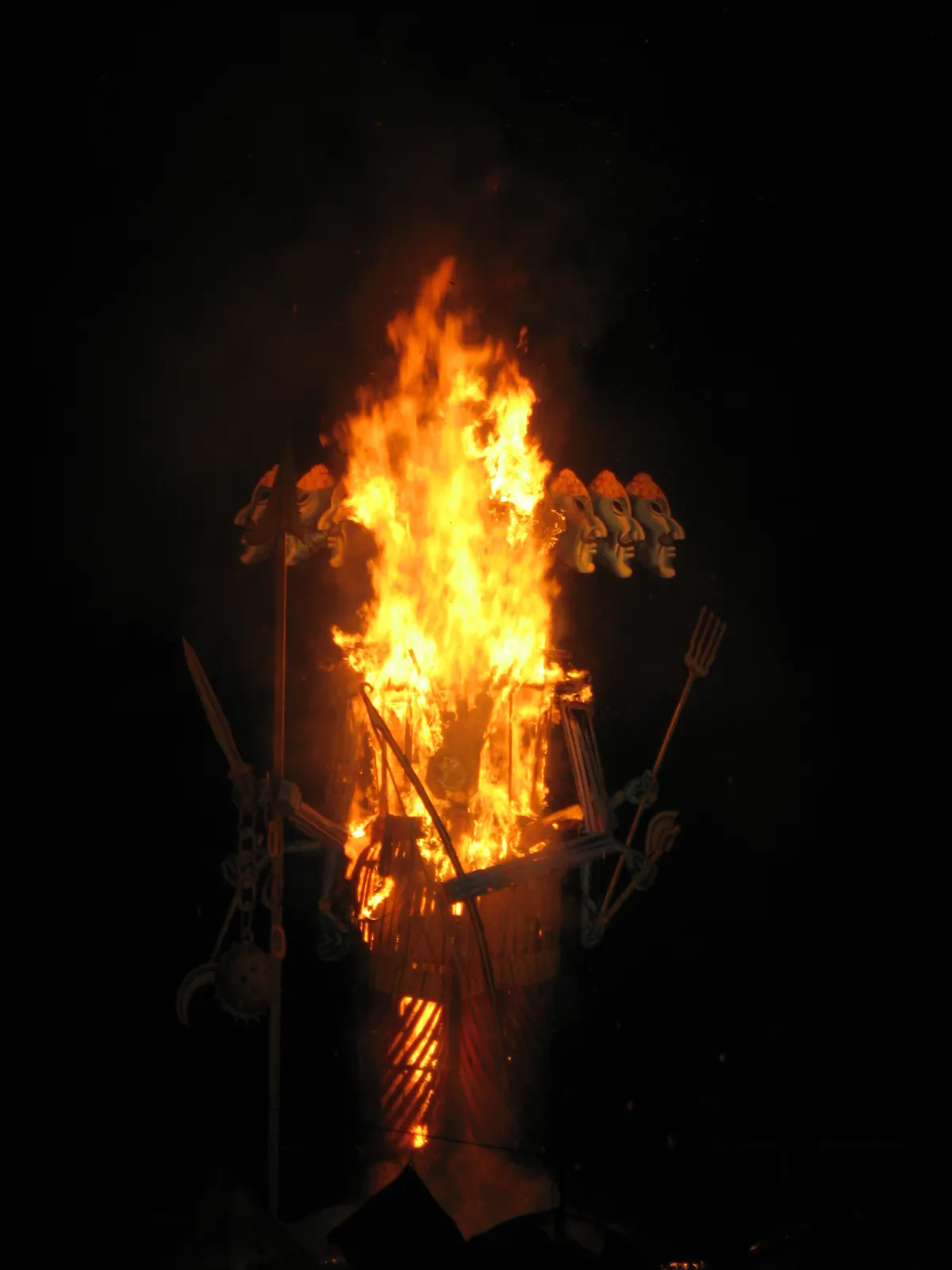 A large Ravana effigy burning against a night sky during Dussehra celebrations.