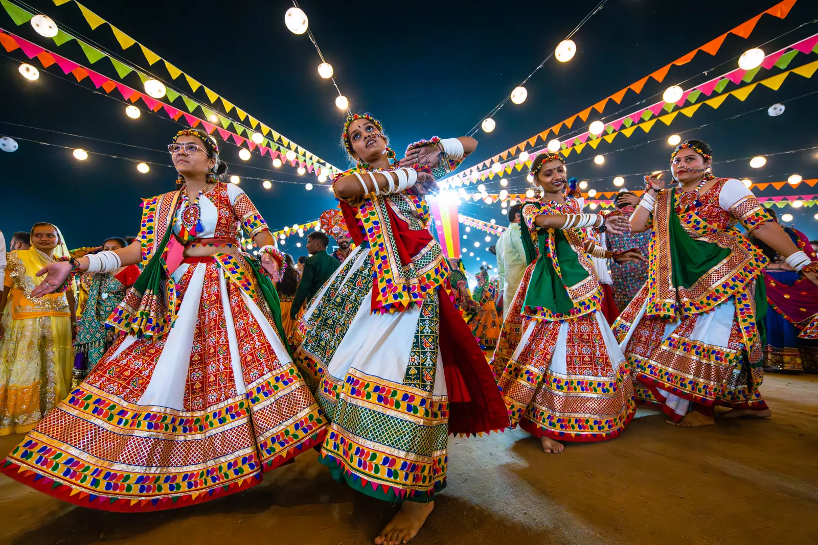 Dancers in colorful traditional outfits at a community Garba night.