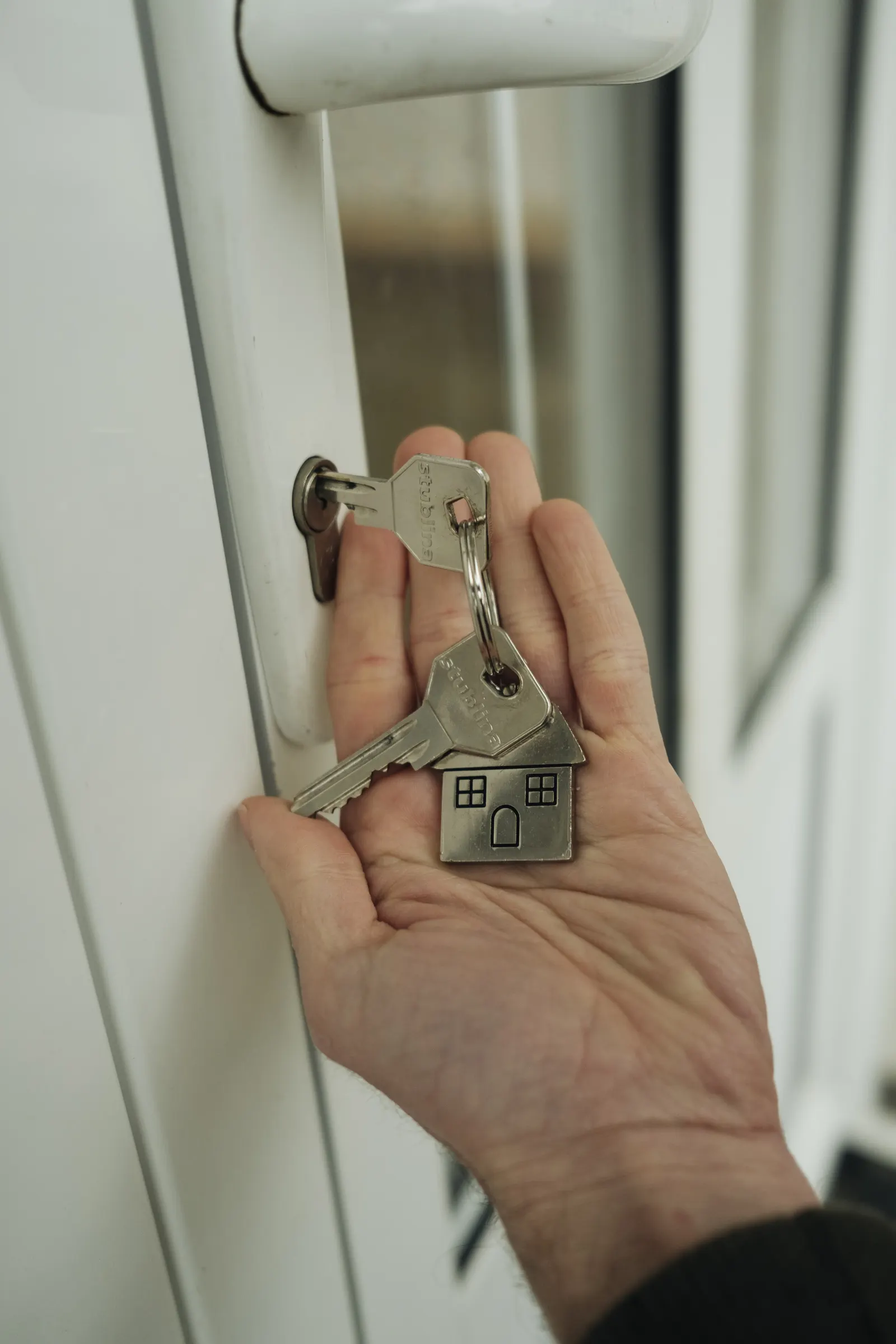 A family holding keys outside their new home.