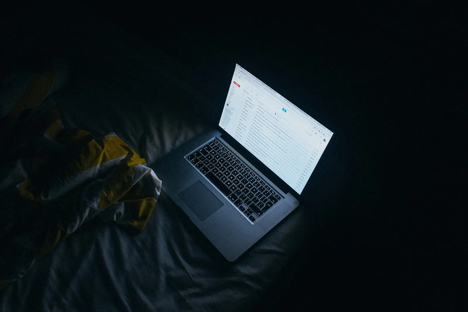 A person carefully reviewing a website on a laptop late at night.