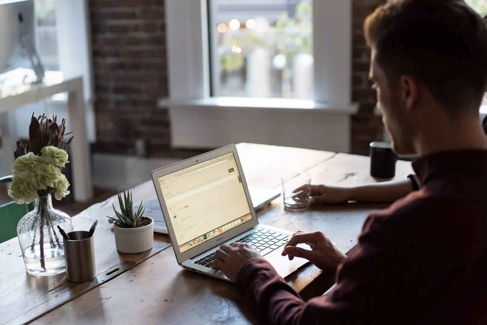 A man looking tired and frustrated while working at a laptop.