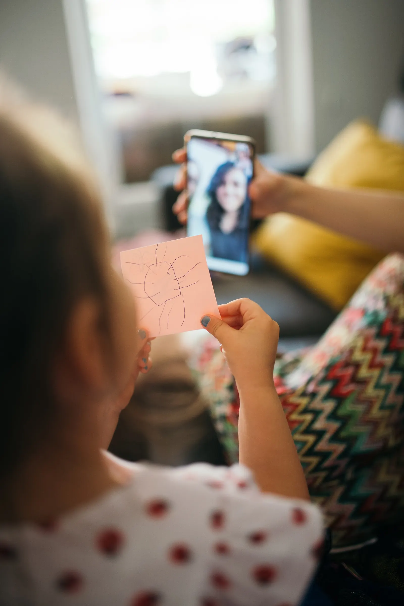 An extended Indian family gathered around a laptop for a video call.