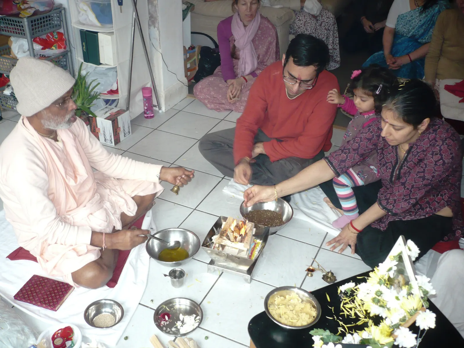 A grandparent and grandchild connected by video call during a family puja ceremony.