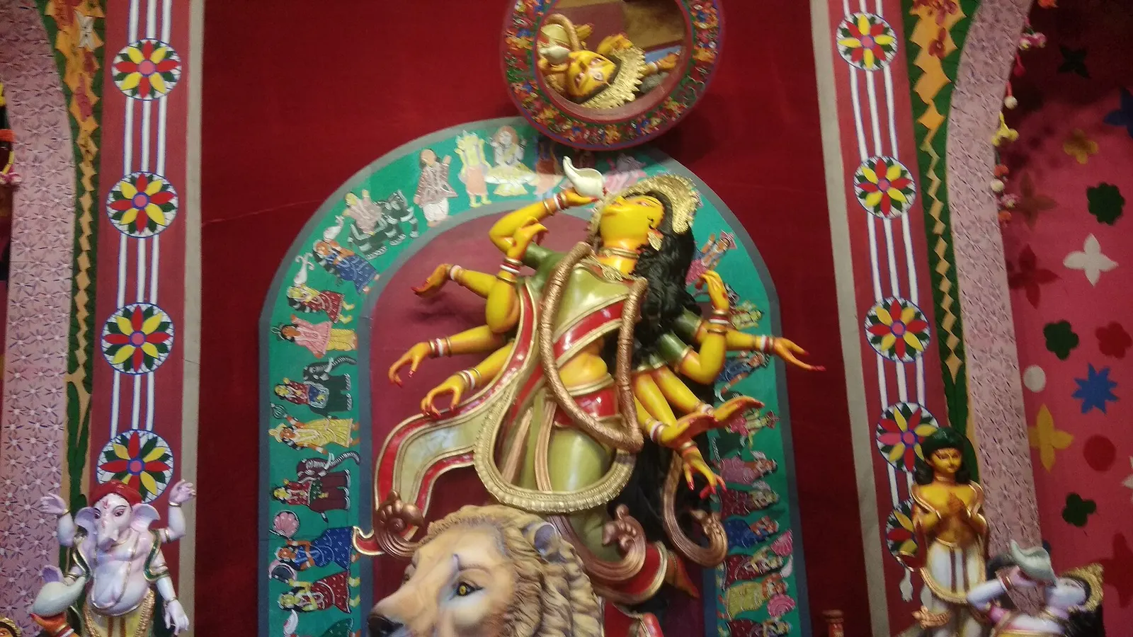 A Durga idol decorated for Navratri celebrations inside a community hall.