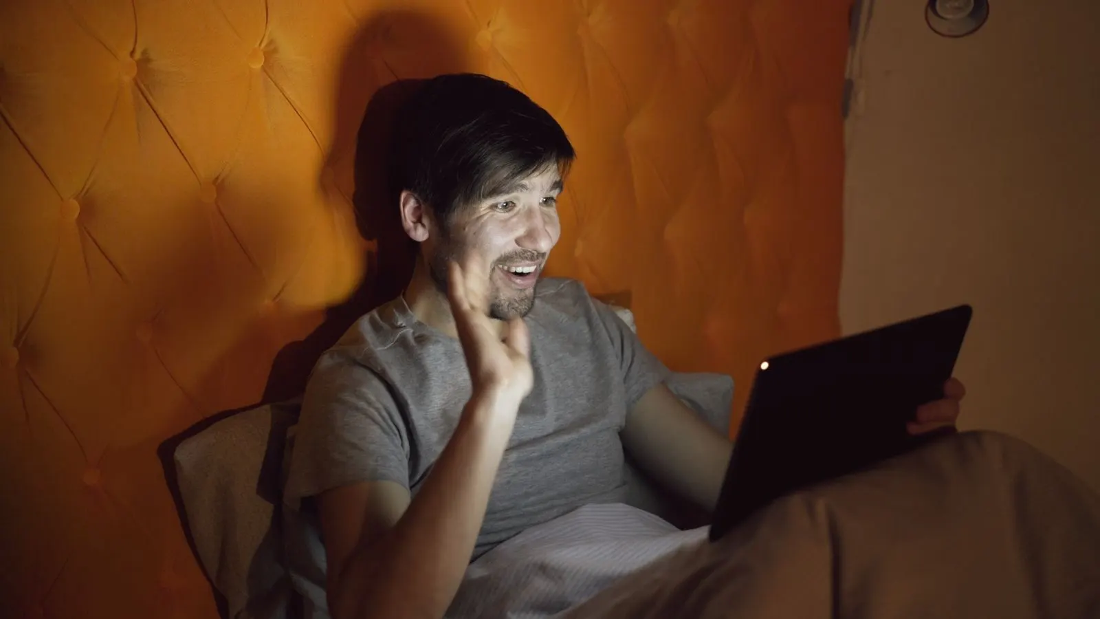 A person holding a phone, video calling family late at night.